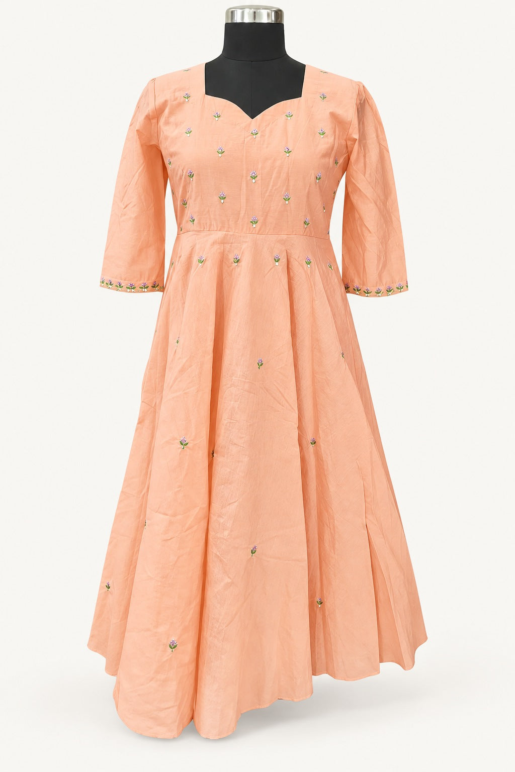 Background-retouched product photograph of the peach floral frock on a mannequin